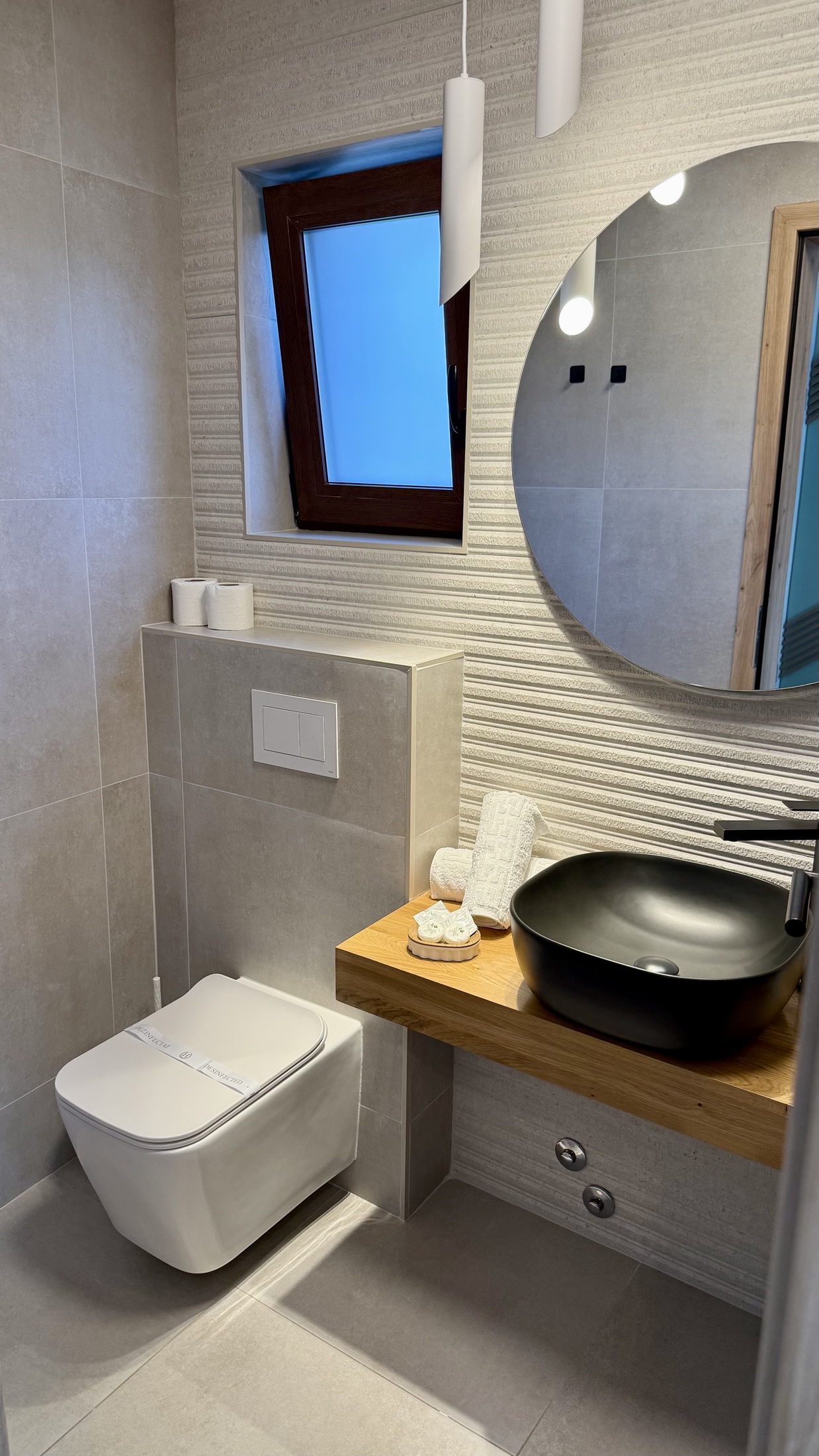 Baie modernă cu oglindă rotundă și cabină de duș